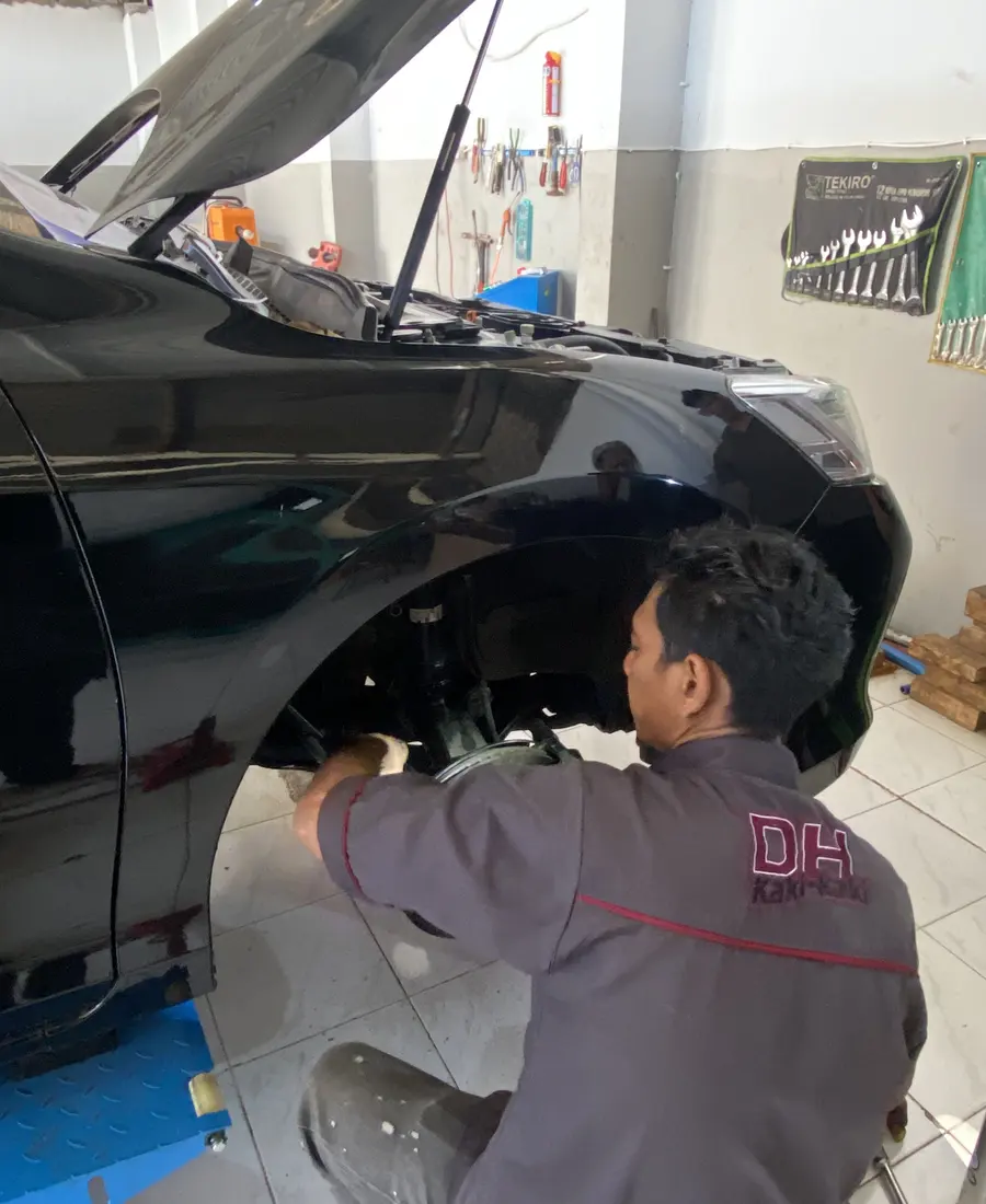 Mekanik DH Kaki-kaki memeriksa kaki-kaki depan